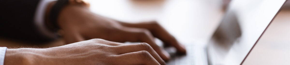male hands typing on laptop keyboard, cropped