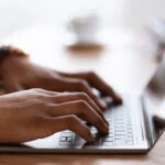 male hands typing on laptop keyboard, cropped