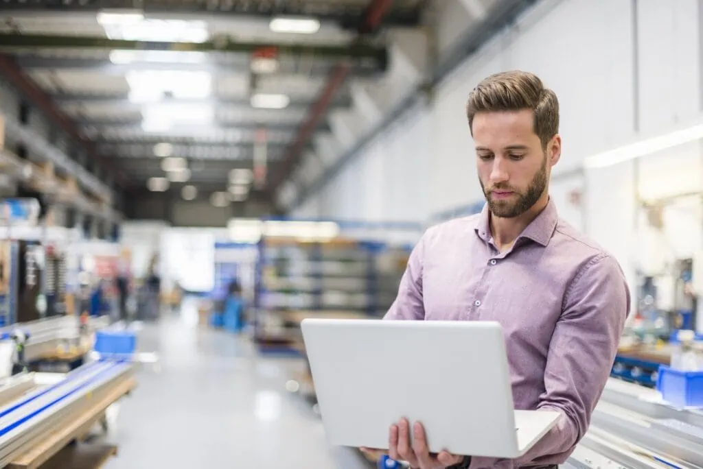 young businessman using laptop in production hall 2022 11 06 23 17 09 utc min