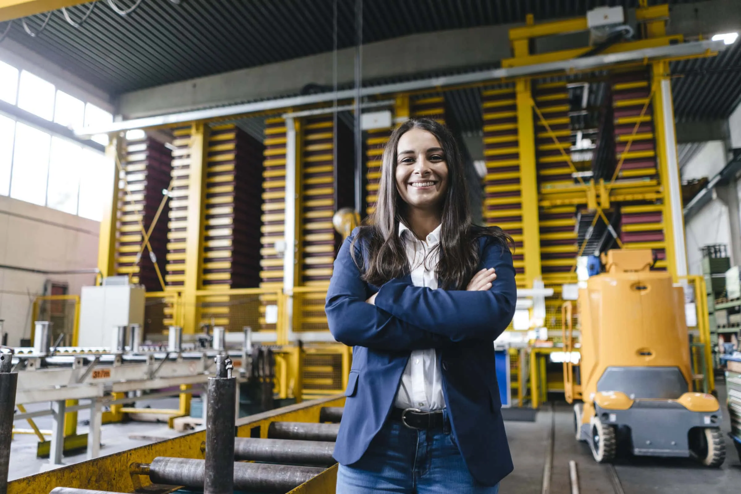 Confident woman standing in logistics center, with arms crossed confident woman standing in logistics center, with arms crossed